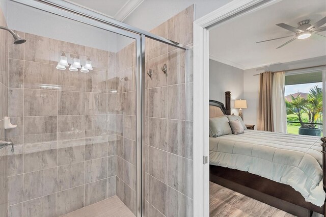 bedroom with hardwood / wood-style floors, ornamental molding, and ceiling fan