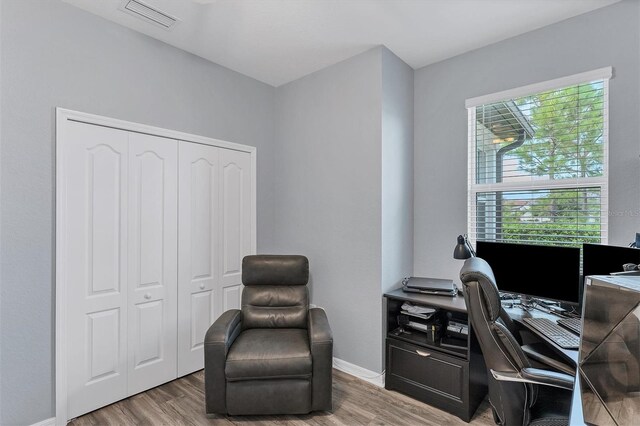 home office with light hardwood / wood-style flooring