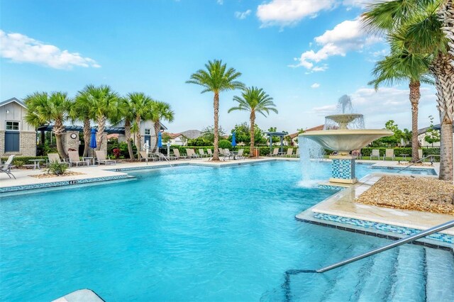 view of swimming pool with pool water feature and a patio