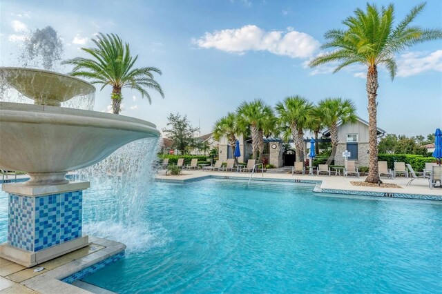 view of pool with a patio and pool water feature