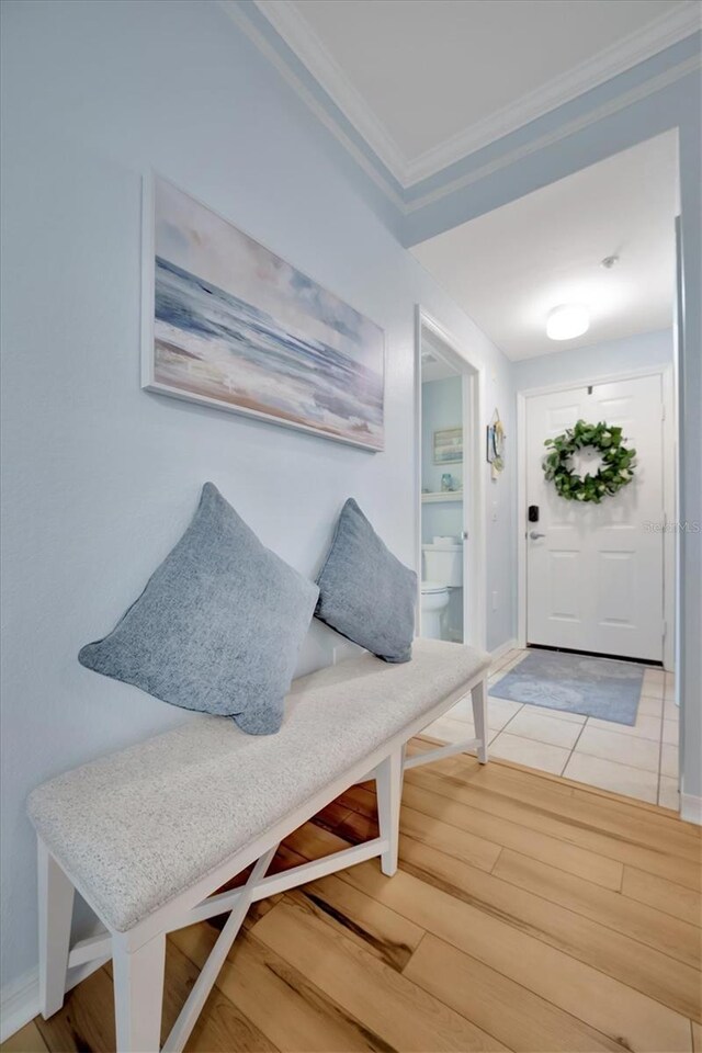 mudroom with wood-type flooring and ornamental molding