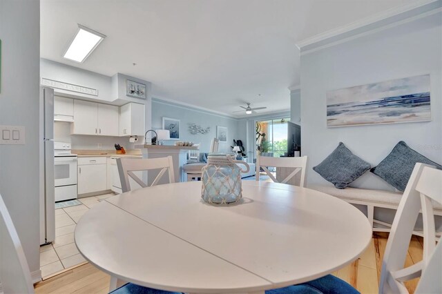 tiled dining room with ceiling fan and ornamental molding