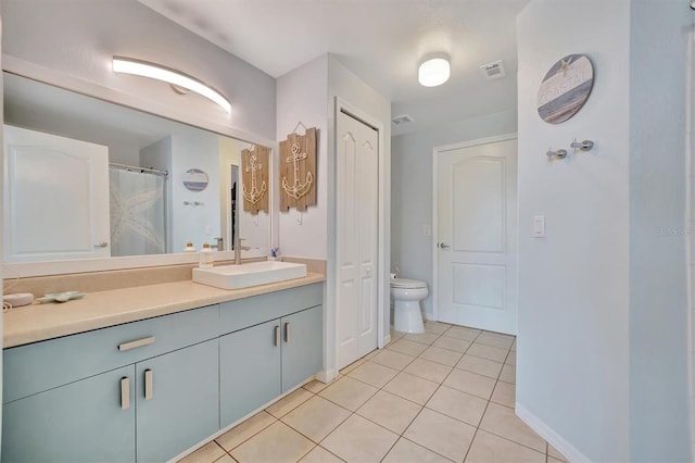 bathroom with tile patterned flooring, vanity, and toilet