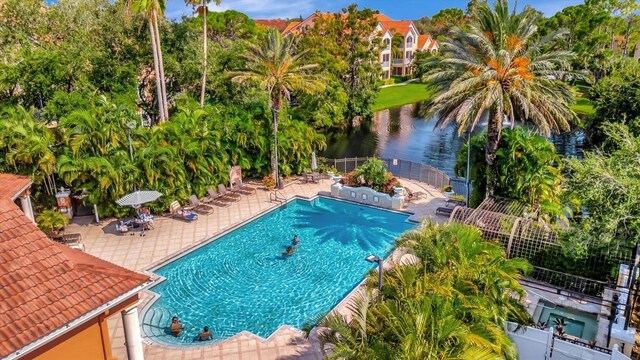 view of pool featuring a patio area and a water view