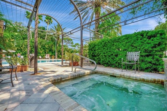 view of pool featuring a patio area and an in ground hot tub