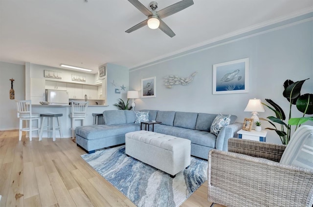 living room with light hardwood / wood-style floors and ceiling fan