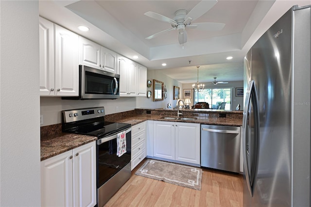 kitchen featuring sink, a raised ceiling, white cabinets, and appliances with stainless steel finishes