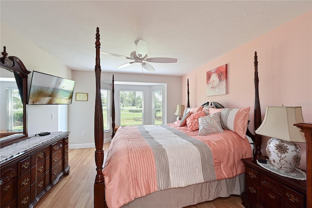 bedroom featuring ceiling fan, light hardwood / wood-style floors, and a textured ceiling