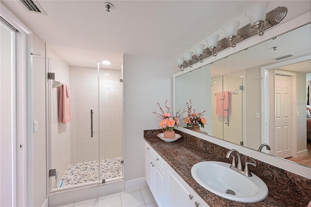 bathroom featuring walk in shower, vanity, and tile patterned flooring