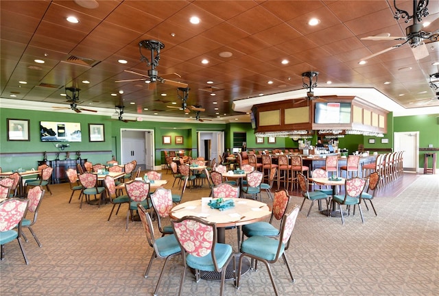 carpeted dining space with ceiling fan