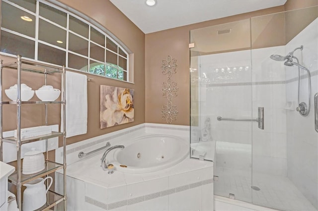 bathroom with a stall shower and a tub with jets