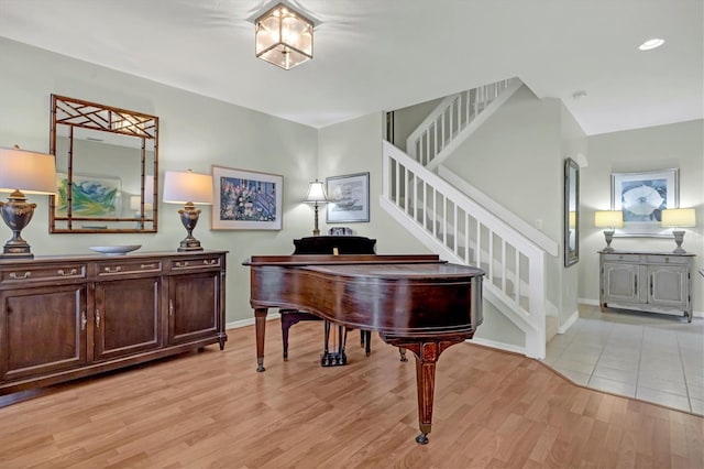 living area with light wood finished floors, stairway, and baseboards