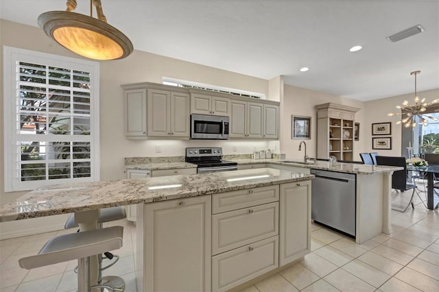 kitchen featuring a center island, an inviting chandelier, decorative light fixtures, light tile patterned floors, and stainless steel appliances