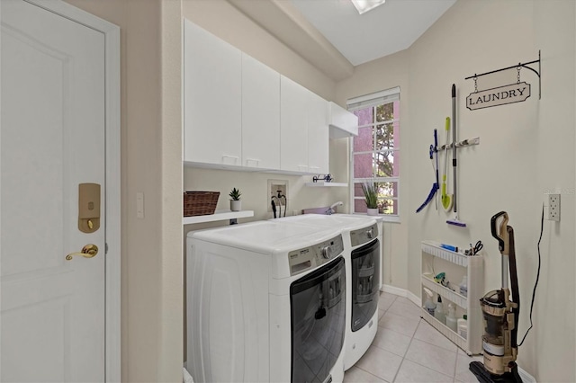 laundry area featuring washer and dryer, cabinets, and light tile patterned floors