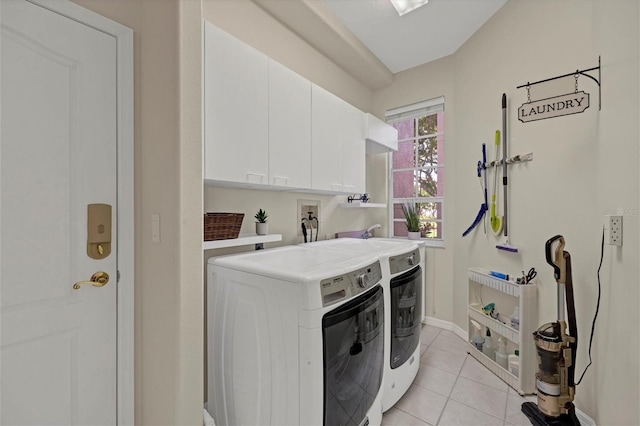 clothes washing area featuring cabinet space, washing machine and dryer, light tile patterned floors, and baseboards