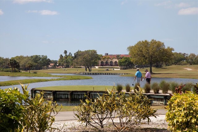 view of home's community with a water view and a yard