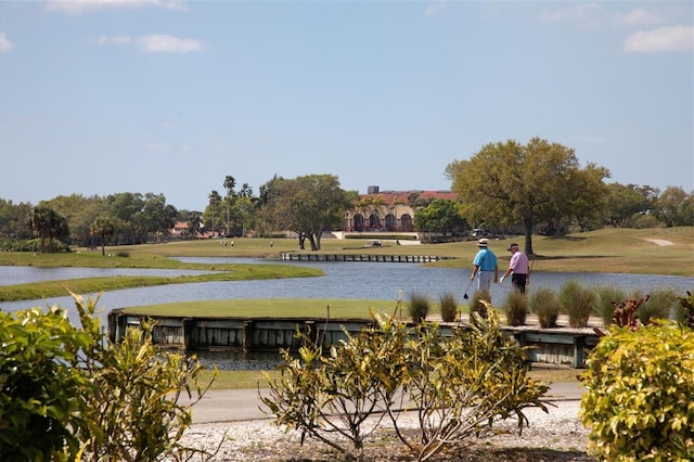 view of property's community with a lawn and a water view