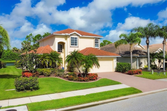 mediterranean / spanish-style house with a tile roof, stucco siding, a front yard, a garage, and driveway