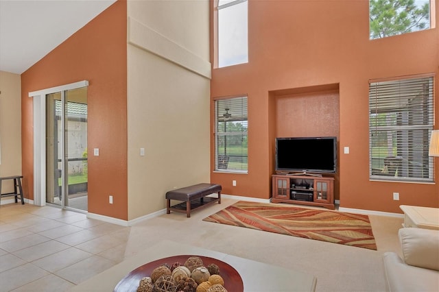 living area with high vaulted ceiling, a wealth of natural light, and light tile patterned floors