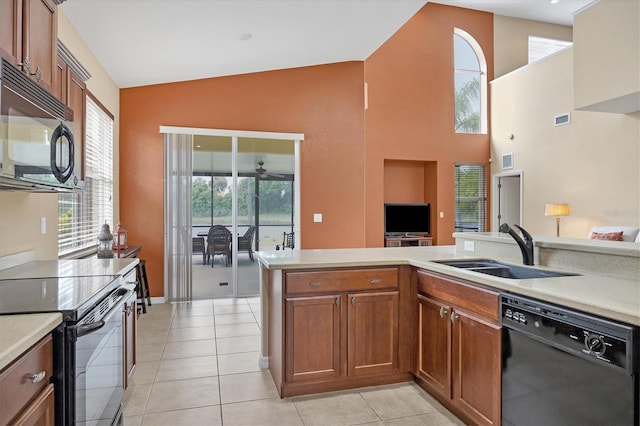 kitchen with lofted ceiling, light countertops, a sink, and black appliances