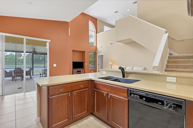 kitchen featuring black dishwasher, light tile patterned floors, a high ceiling, brown cabinetry, and a sink