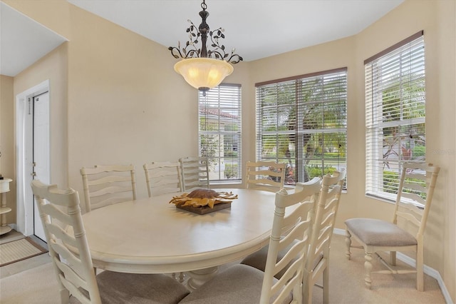 carpeted dining area featuring baseboards