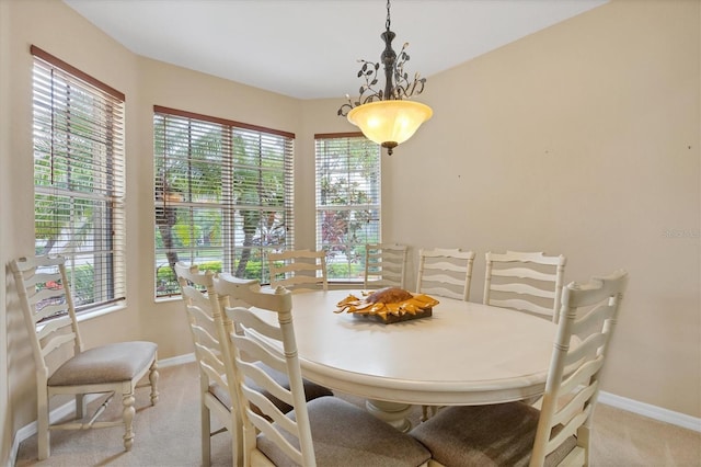 dining area featuring baseboards and light colored carpet