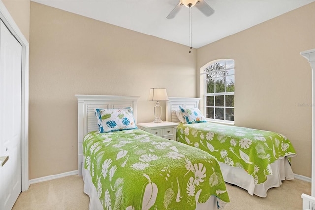 carpeted bedroom with ceiling fan and baseboards