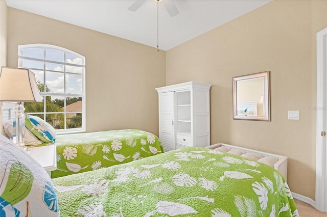 bedroom with baseboards, a ceiling fan, vaulted ceiling, carpet flooring, and a closet