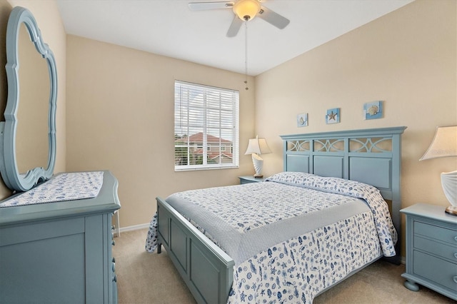 bedroom with light carpet, baseboards, and a ceiling fan