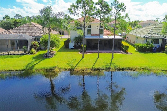 exterior space featuring a tile roof, glass enclosure, a water view, and a yard