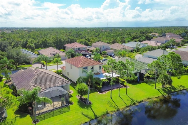 drone / aerial view with a residential view, a water view, and a forest view