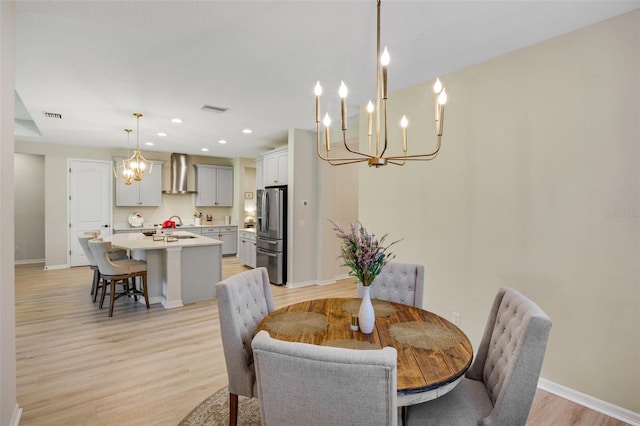 dining area featuring light hardwood / wood-style flooring and a chandelier