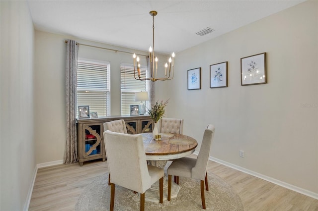 dining space with an inviting chandelier and light hardwood / wood-style floors