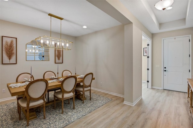 dining space with a notable chandelier and light hardwood / wood-style flooring