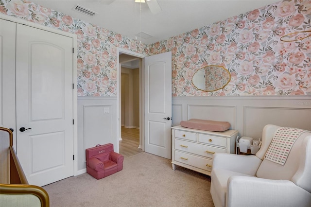 living area featuring light colored carpet and ceiling fan