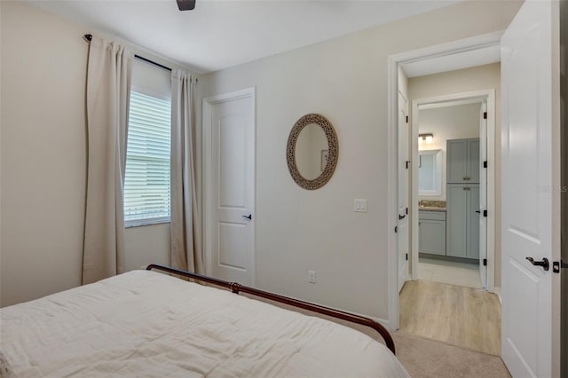 bedroom featuring light carpet and ensuite bathroom