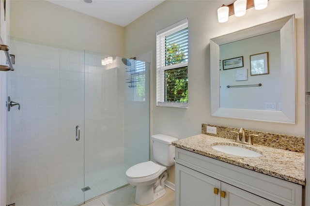 bathroom featuring tile patterned floors, vanity, toilet, and a shower with shower door