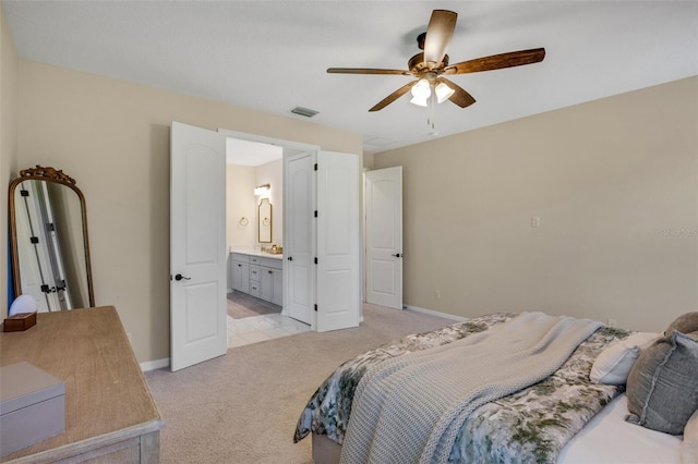 carpeted bedroom with ceiling fan and ensuite bath