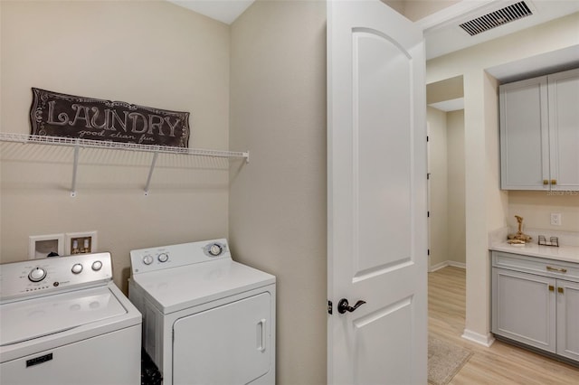 clothes washing area with light hardwood / wood-style flooring and washer and clothes dryer