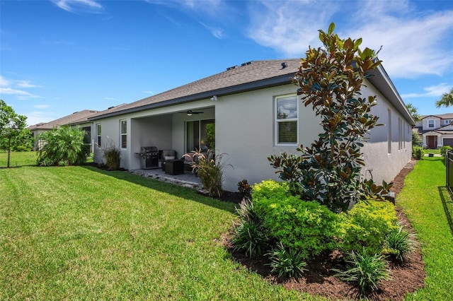 rear view of property featuring a patio area, ceiling fan, and a lawn