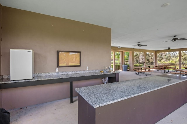 view of patio featuring a bar and ceiling fan