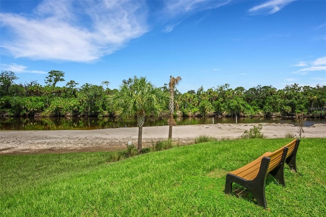 view of home's community featuring a lawn and a water view