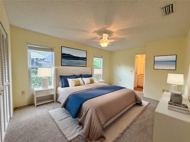 carpeted bedroom with a textured ceiling and ceiling fan