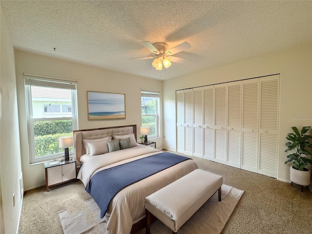 bedroom featuring a closet, ceiling fan, light carpet, and a textured ceiling