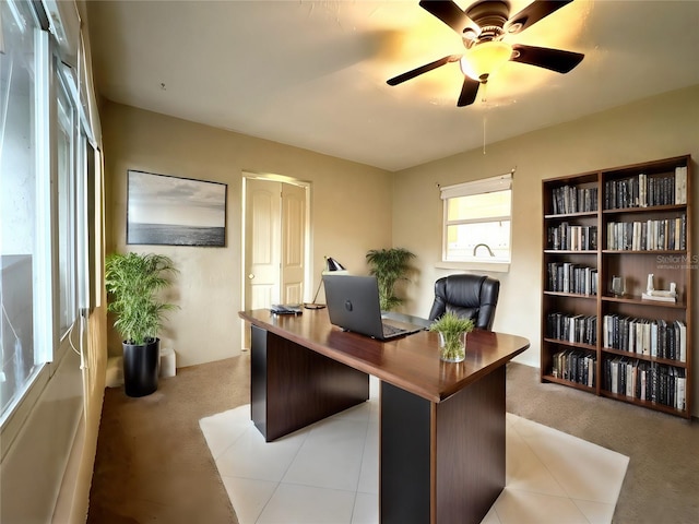 carpeted office space with ceiling fan