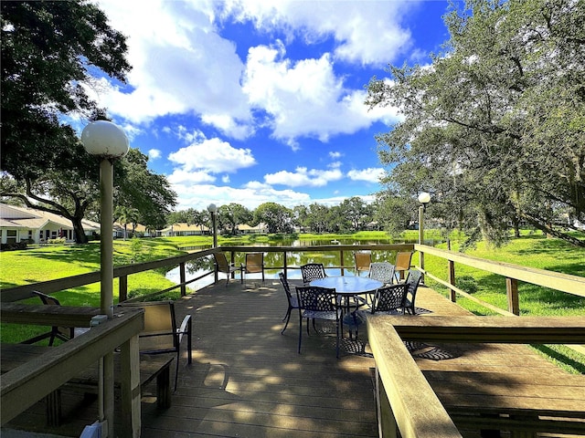 wooden terrace with a lawn and a water view