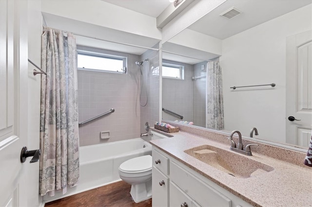 full bathroom featuring toilet, a wealth of natural light, hardwood / wood-style flooring, and vanity