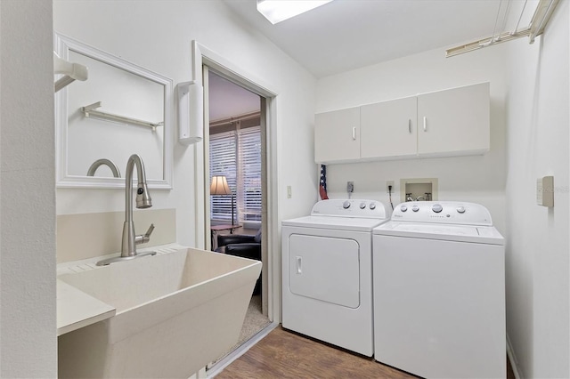 washroom featuring dark hardwood / wood-style floors, sink, cabinets, and washing machine and dryer