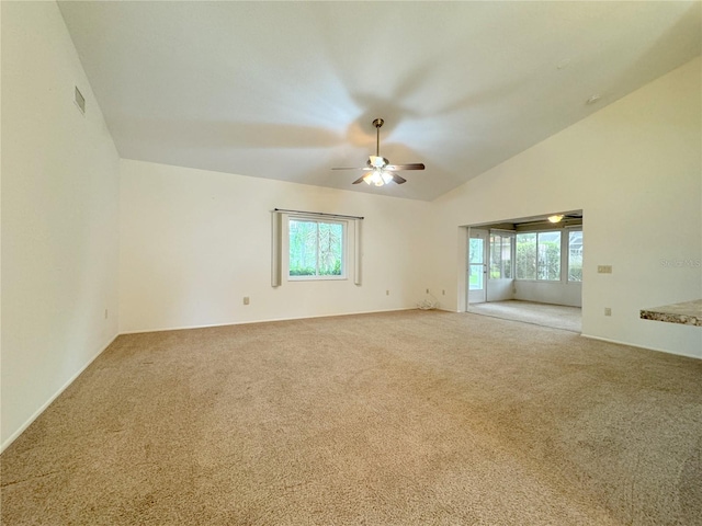 carpeted empty room with lofted ceiling, ceiling fan, and plenty of natural light